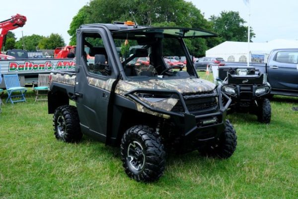 “Polaris Ranger XP 1000 camo utility side by side ATV on display at outdoor farm equipment show