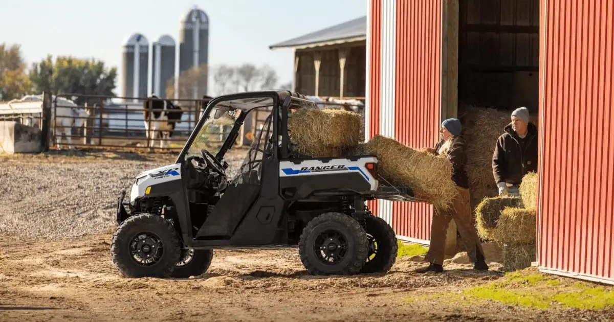 A Polaris Ranger on a farm with hay being loaded into it