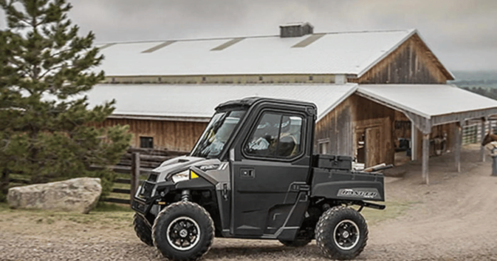 A Polaris Ranger on the farm with a barn in the background