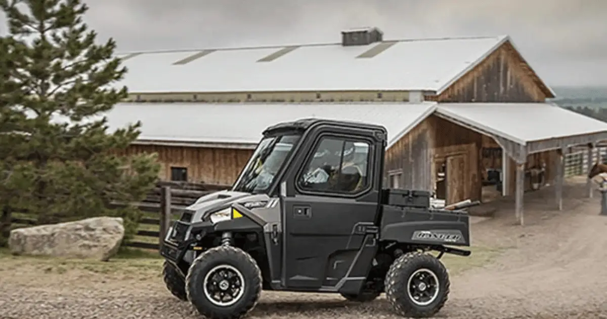 A Polaris Ranger on the farm with a barn in the background