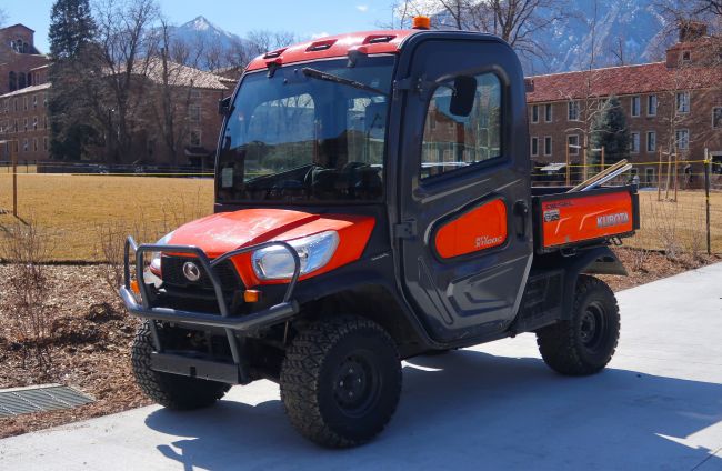 Kubota RTV-X1100C side-by-side utility vehicle with enclosed cab parked outdoors
