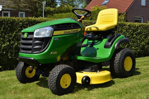 John Deere X125 riding lawn mower with yellow seat and mower deck on a freshly cut lawn