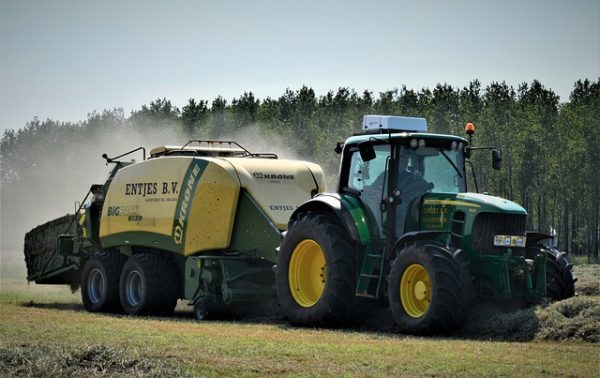 John Deere tractor pulling Krone Big Pack baler collecting hay on farmland