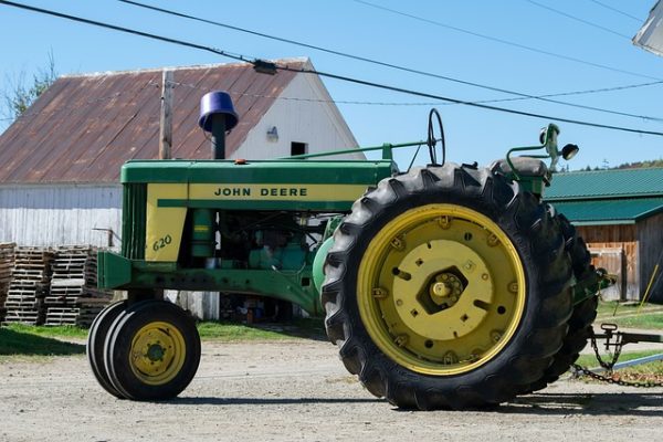 John Deere 620 tractor rear tire and rim, side view on farm.